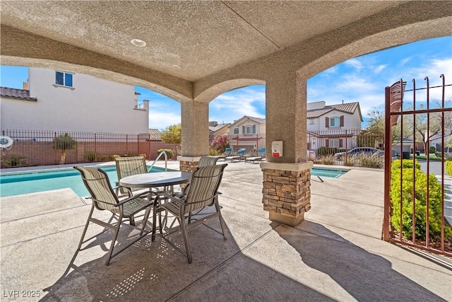 view of patio / terrace featuring a residential view, a community pool, and a fenced backyard