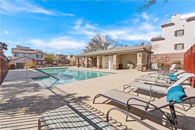 pool with a patio area, a residential view, and fence