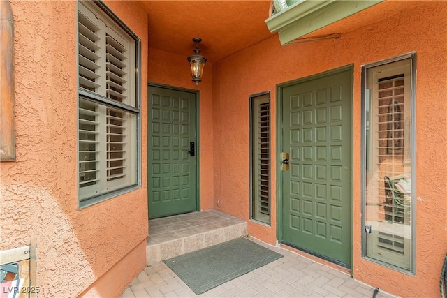 view of exterior entry featuring stucco siding