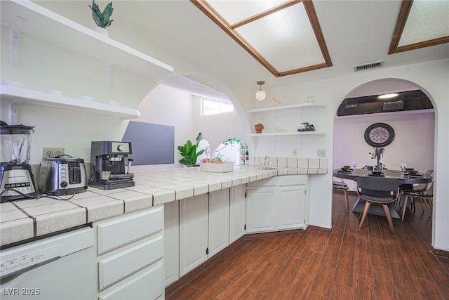 kitchen with visible vents, white cabinets, dishwasher, tile countertops, and open shelves