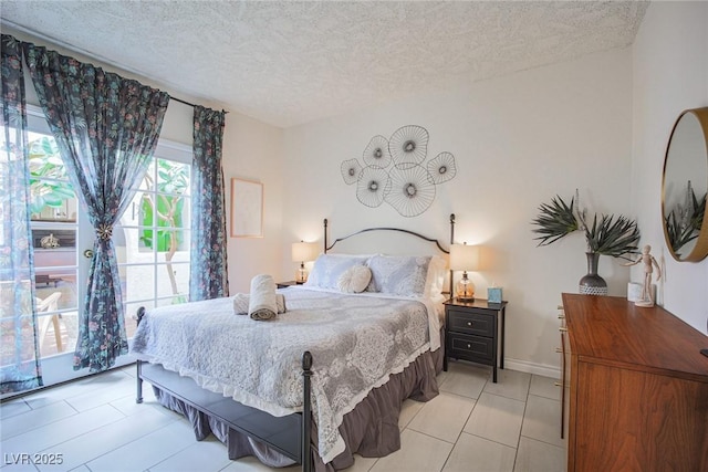 bedroom with a textured ceiling and baseboards