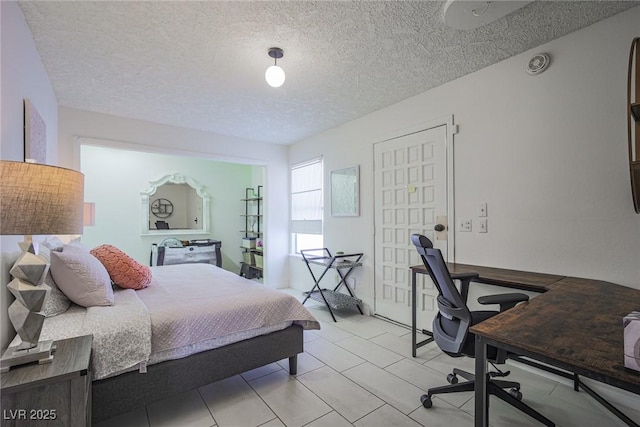 bedroom with light tile patterned flooring and a textured ceiling