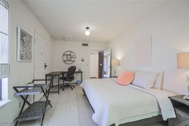 bedroom featuring visible vents, a textured ceiling, and light tile patterned floors