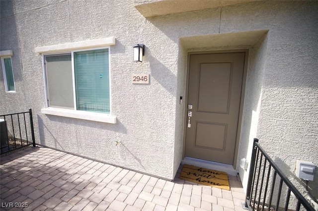 property entrance with stucco siding