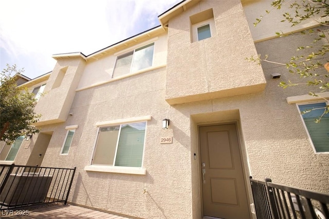 doorway to property featuring stucco siding