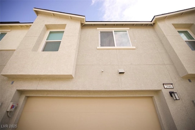 view of property exterior featuring an attached garage and stucco siding