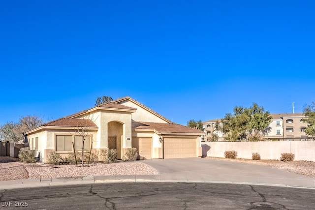 mediterranean / spanish house with a garage, fence, driveway, and stucco siding