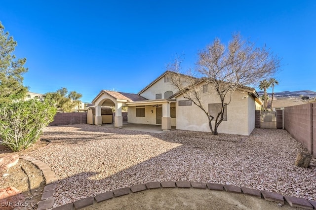 view of front of property featuring a patio area, a fenced backyard, and stucco siding