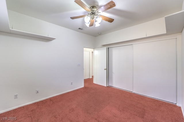 unfurnished bedroom featuring carpet, a closet, visible vents, a ceiling fan, and baseboards