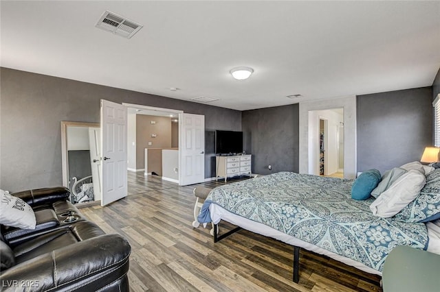 bedroom featuring baseboards, visible vents, and wood finished floors