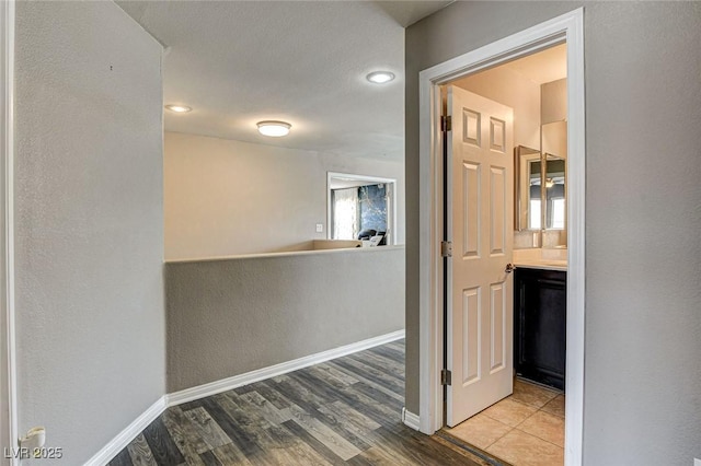 hall featuring wood finished floors and baseboards