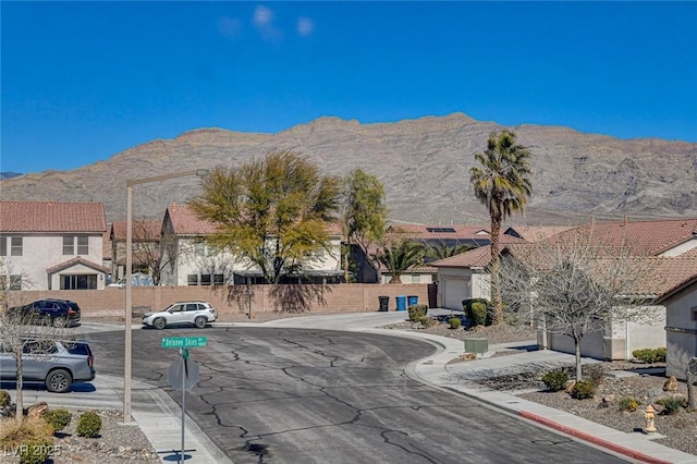 view of road featuring a residential view, a mountain view, and curbs