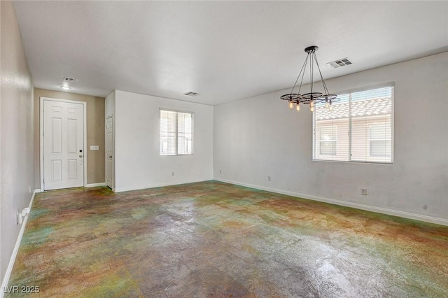 spare room with concrete floors, an inviting chandelier, visible vents, and baseboards