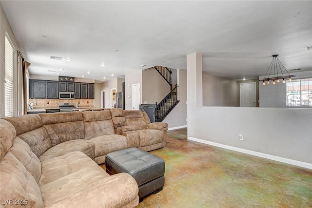 living room featuring visible vents, concrete floors, baseboards, and stairs