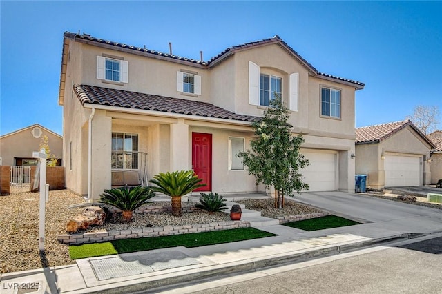 mediterranean / spanish house with a garage, concrete driveway, a tiled roof, and stucco siding