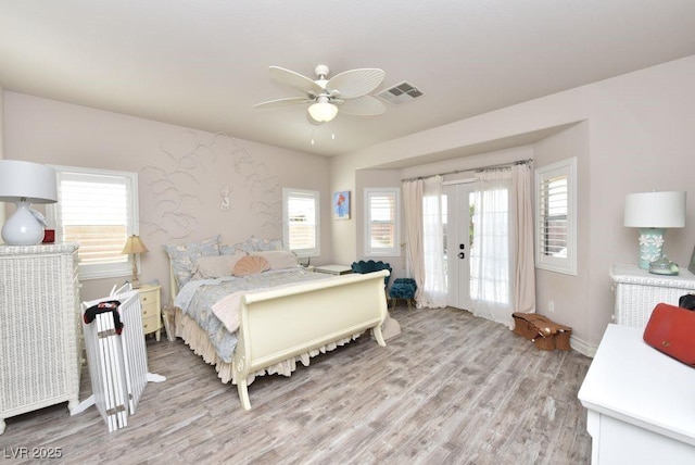 bedroom featuring light wood-style flooring, multiple windows, visible vents, and french doors