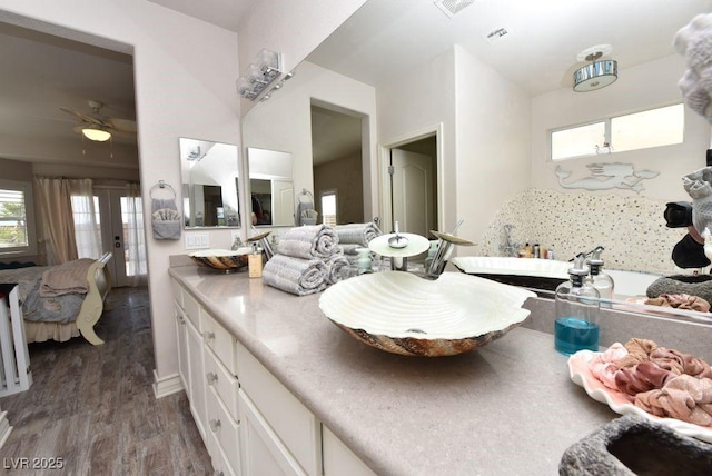 ensuite bathroom with double vanity, visible vents, ceiling fan, connected bathroom, and wood finished floors