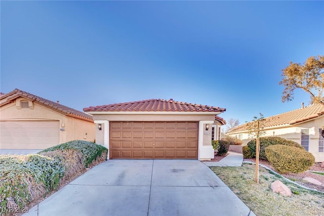 mediterranean / spanish-style house with a garage, a tile roof, driveway, and stucco siding