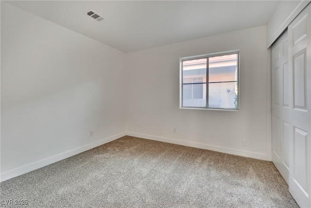 carpeted empty room with visible vents and baseboards