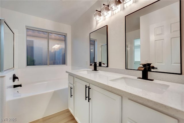 bathroom featuring wood finished floors, a garden tub, a sink, and double vanity