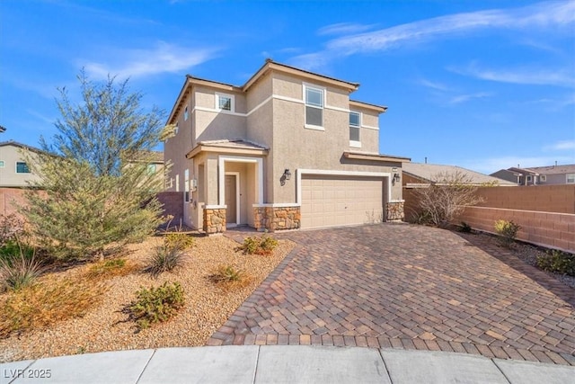 view of front of home with a garage, stone siding, fence, decorative driveway, and stucco siding