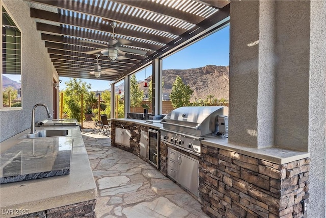 view of patio / terrace featuring area for grilling, ceiling fan, a sink, exterior kitchen, and a pergola