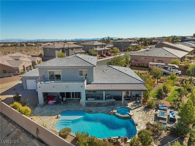 back of property featuring a pool with connected hot tub, a residential view, a fenced backyard, and a patio