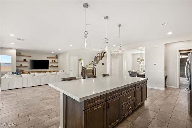 kitchen with light countertops, a kitchen island, visible vents, and recessed lighting