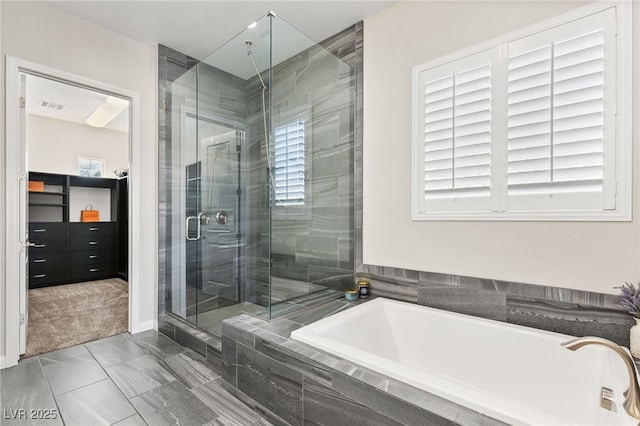 full bathroom with a stall shower, a garden tub, and plenty of natural light