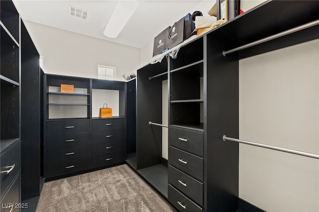 walk in closet featuring visible vents and light colored carpet