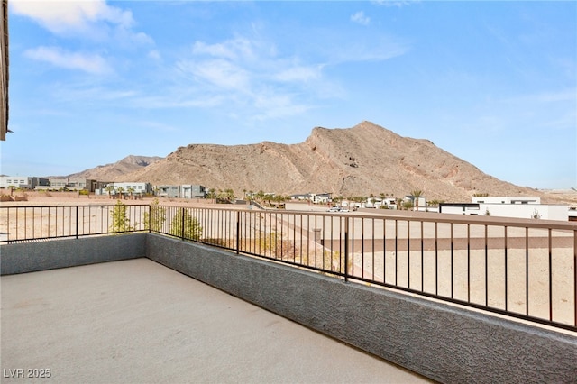 view of patio with a balcony and a mountain view