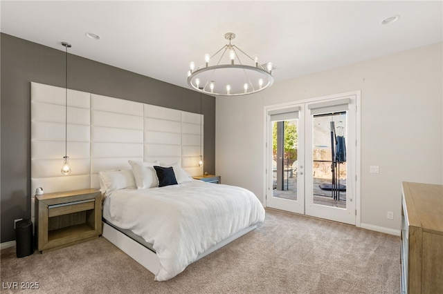 carpeted bedroom featuring access to exterior, baseboards, and an inviting chandelier