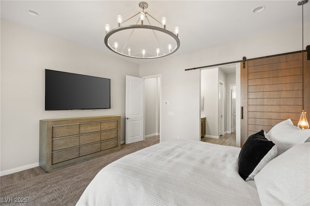 bedroom featuring an inviting chandelier, a barn door, baseboards, and carpet