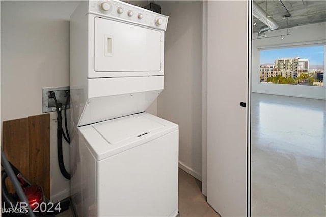 laundry area featuring laundry area, a city view, and stacked washer / dryer