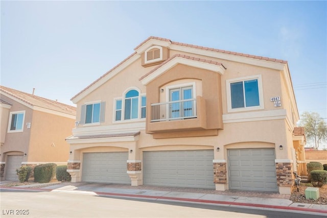 view of front facade featuring a garage, stone siding, and stucco siding