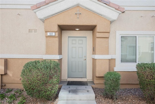 entrance to property featuring stucco siding