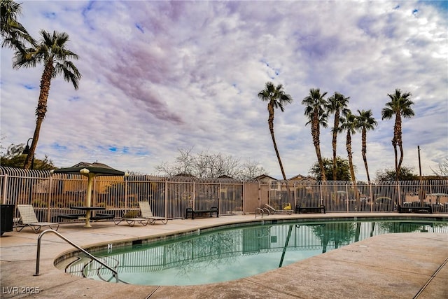 community pool with fence and a patio