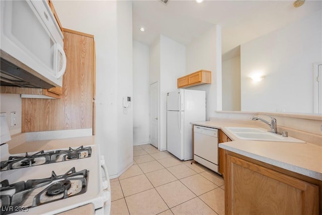 kitchen with light tile patterned floors, light countertops, white appliances, and a sink