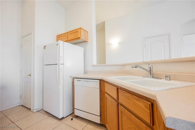 kitchen with light countertops, white appliances, light tile patterned flooring, and a sink