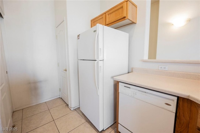 kitchen featuring light countertops, white appliances, and light tile patterned flooring