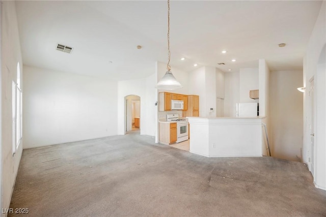 kitchen with arched walkways, light colored carpet, visible vents, open floor plan, and white appliances