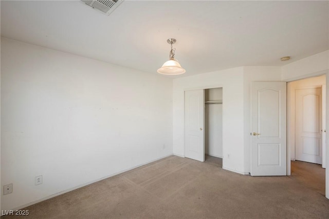 unfurnished bedroom with carpet floors, a closet, and visible vents