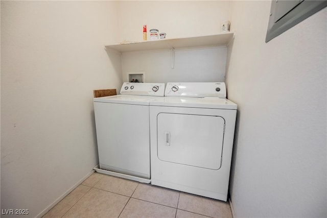 washroom with laundry area, light tile patterned flooring, washing machine and clothes dryer, and baseboards