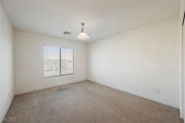 spare room with visible vents and light colored carpet