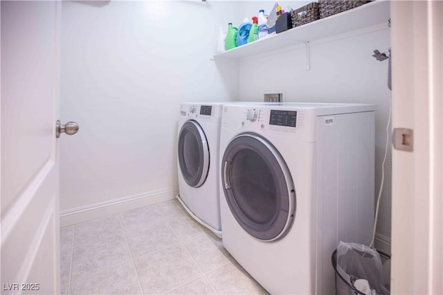 washroom with washing machine and dryer, laundry area, baseboards, and light tile patterned floors