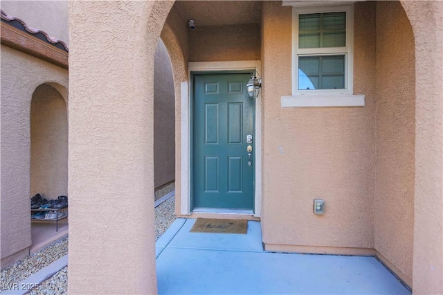 view of exterior entry featuring stucco siding