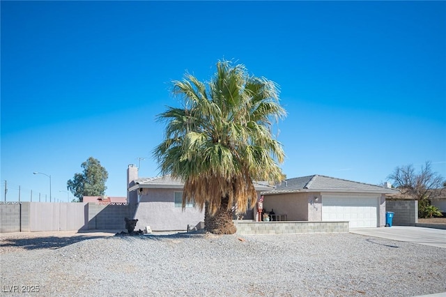 view of front facade featuring a garage, fence, driveway, and stucco siding