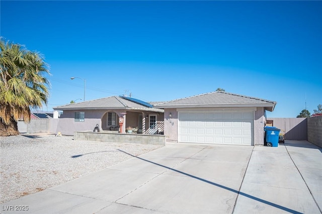 ranch-style home with a garage, driveway, fence, and stucco siding