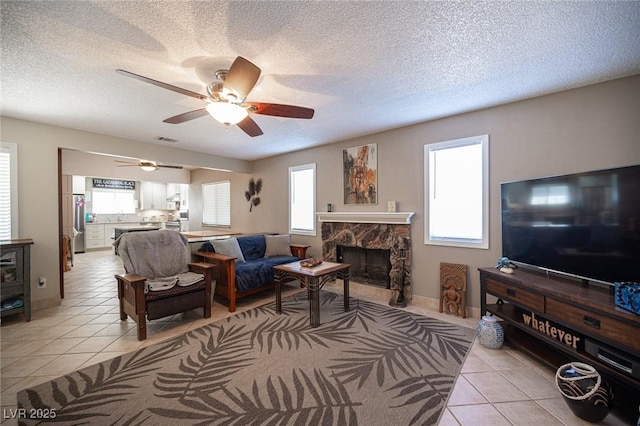 living area with plenty of natural light, a fireplace, and light tile patterned flooring