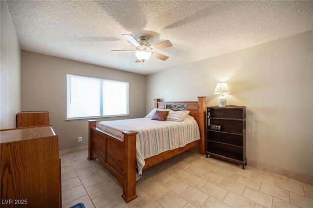 bedroom featuring a ceiling fan, a textured ceiling, baseboards, and light tile patterned floors